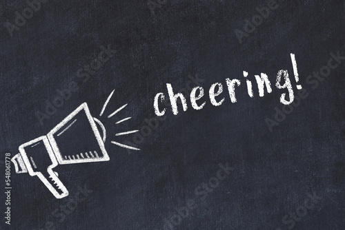 Chalk loudspeaker and inscription cheering on black chalkboard