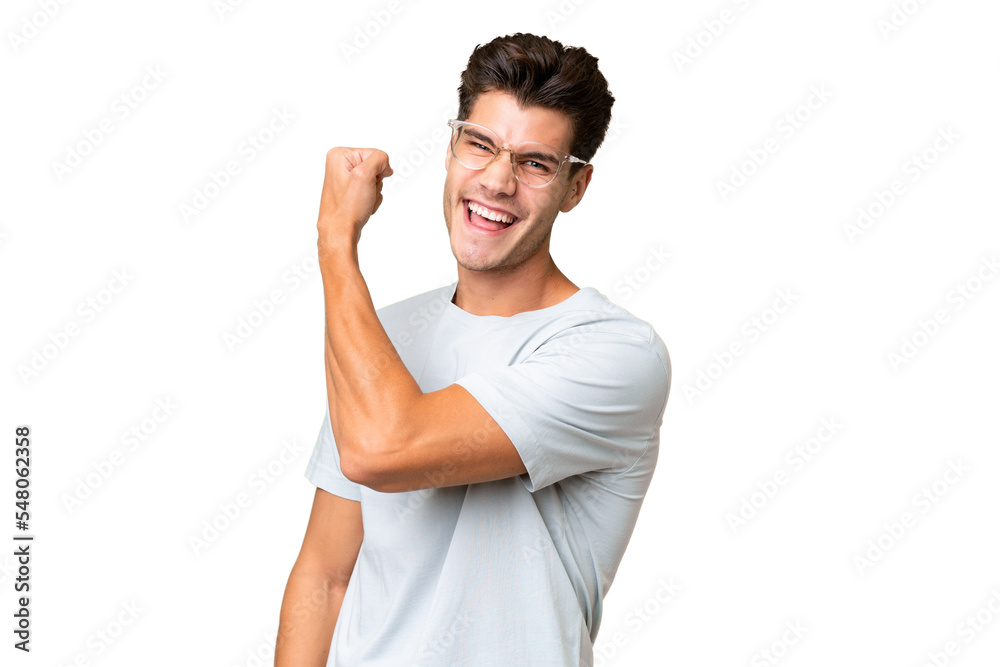 Young caucasian handsome man over isolated background doing strong gesture Young caucasian handsome man over isolated background doing strong gesture