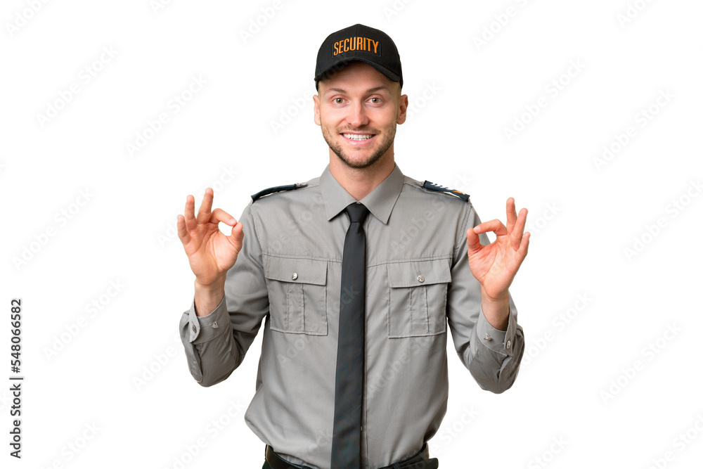 Young security caucasian man over isolated background showing an ok sign with fingers Young security caucasian man over isolated background showing an ok sign with fingers