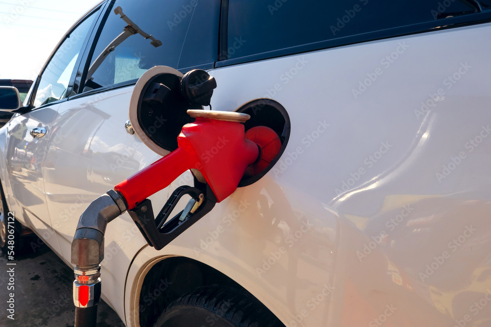 Filling a car with fuel at a gas station. The car fills up with