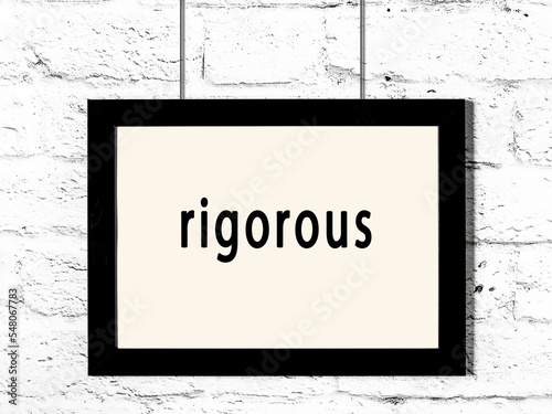 Black frame hanging on white brick wall with inscription rigorous