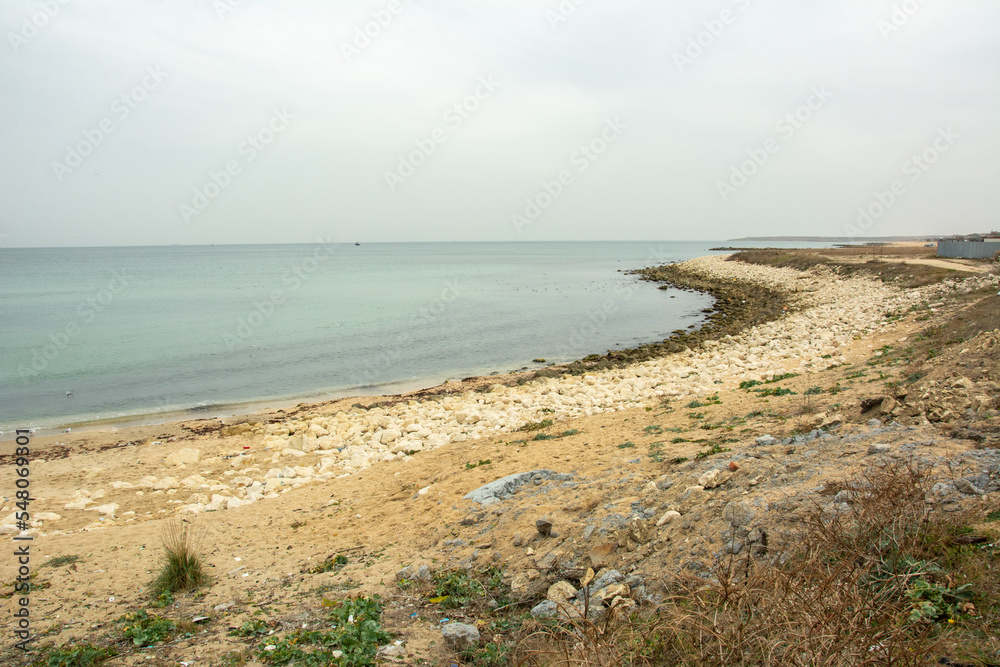 View of the Black Sea shore and rocky beach with Karaburun fishing village at the back near Istanbul, Turkey