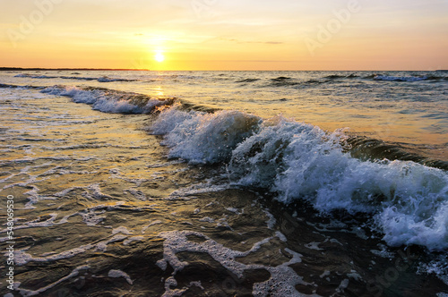 Sunset over the sea. Reflection of sunlight in the sea waves. The sky in the sunset rays.