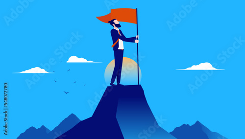 Businessman on mountaintop with flag - Business person standing on top of mountain holding red flag and being proud of achievement and success. Flat design vector illustration with blue background
