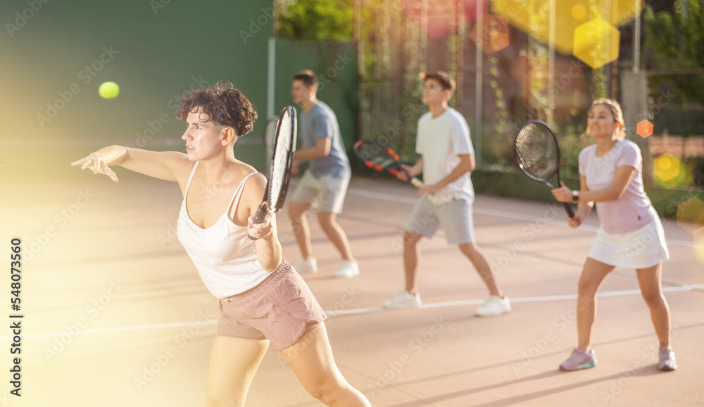 Latin woman serving ball during frontenis game outdoors. Woman playing pelota on outdoor fronton.