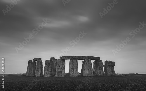 A moody black and white image of the iconic prehistoric neolithic standing stone circle Stonehenge, a pagan site of ritual dating back to the Bronze Age, at Salisbury Plain, Wiltshire, England, UK. photo