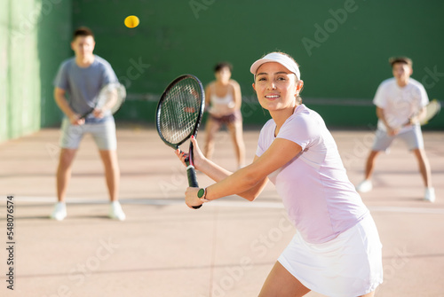 Expressive resolved fit girl playing frontenis ball friendly match on outdoors court