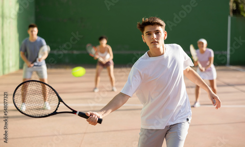 Young man playing frontenis on outdoor pelota court during training. Man playing Basque pelota speciality. © JackF