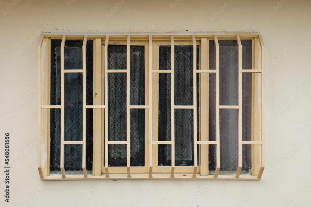 Window Divided into Four Light Yellow Sections with White Bars Window Divided into Four Light Yellow Sections with White Bars