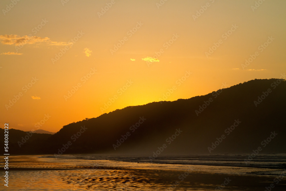 Sao Sebastiao beach with sunrise with vibrant color and sunset sky with cloud on a sunny day.