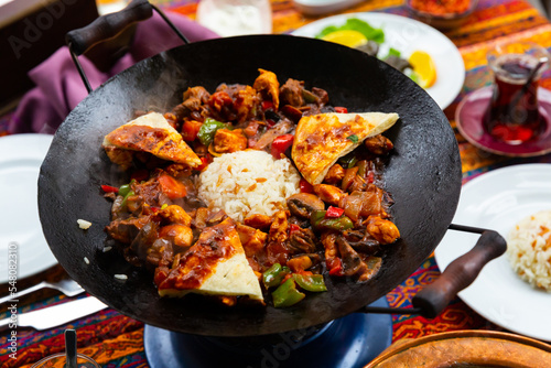 Turkish meat saute coban kavurma with pita and rice in traditional black pan