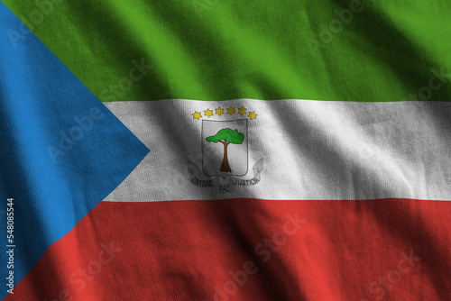 Equatorial Guinea flag with big folds waving close up under the studio light indoors. The official symbols and colors in banner photo