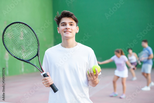 Portrait of cheerful caucasian man frontenis player in outdoor court photo