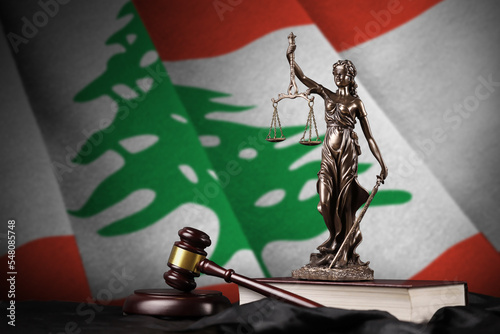 Lebanon flag with statue of lady justice, constitution and judge hammer on black drapery. Concept of judgement and guilt