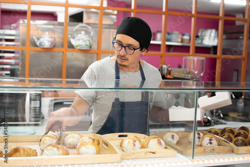 Baker selects the croissant to dispatch the order
