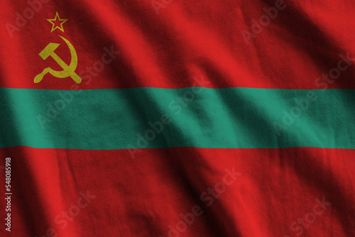 Transnistria flag with big folds waving close up under the studio light indoors. The official symbols and colors in banner