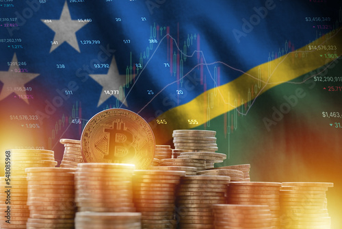 Solomon Islands flag and big amount of golden bitcoin coins and trading platform chart. Crypto currency photo
