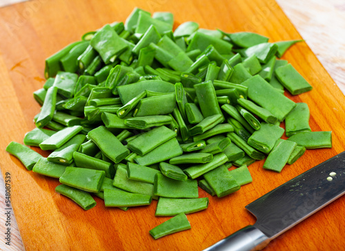 Chopped raw flat beans on wooden table. Healthy vegetarian nutrition .. photo