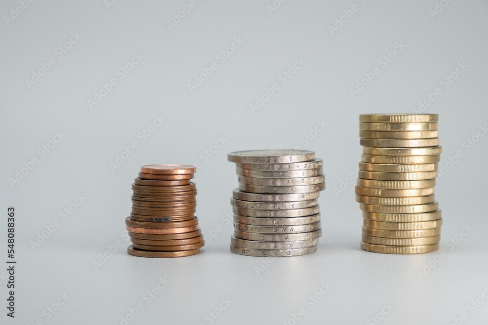 Coins stacked on a light gray background. Money coins saving concept side view. Copy space. Coins stacked on a light gray background. Money coins saving concept side view. Copy space.