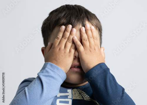 Male boy about 4 years old expressing emotions with his hands on his face