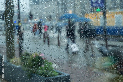 ludzie w deszczu na ulicy miasta