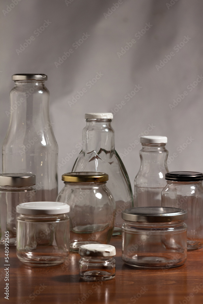photo of reusable glass containers for food storage - bottles and jars on a wooden table photo of reusable glass containers for food storage - bottles and jars on a wooden table