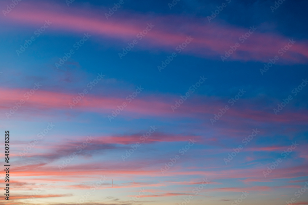 Striped crisscrossing twilight cloudy sky