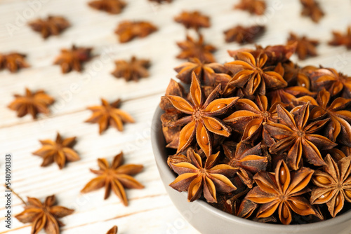 Many aromatic anise stars on white wooden table, closeup