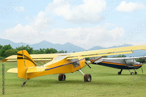 View of beautiful ultralight airplanes in field on autumn day photo