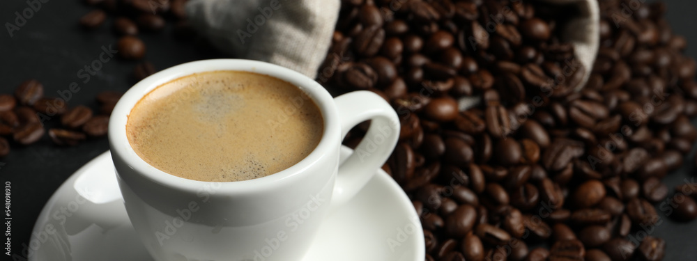 Fototapeta premium Cup of aromatic coffee and beans on grey table, space for text. Banner design