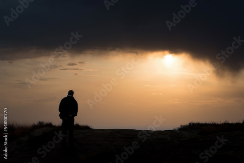 silhouette of a person standing on a rock