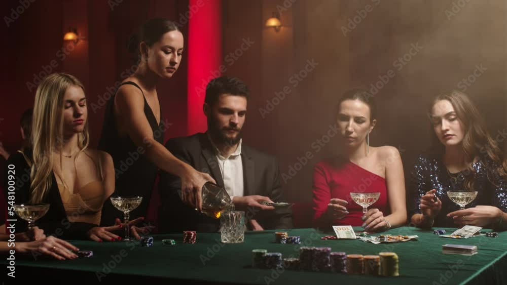 Bearded man and young women stare at their poker playing cards, make bets while playing in the casino. Entertainment industry and luxury lifestyle. The concept of gambling in the casino and poker.
Bearded man and young women stare at their poker playing cards, make bets while playing in the casino. Entertainment industry and luxury lifestyle. The concept of gambling in the casino and poker.