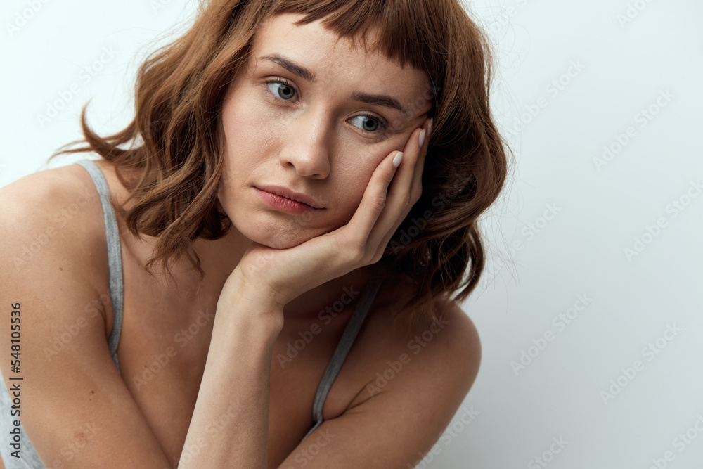 a pleasant, beautiful, tanned woman stands with a thoughtful, relaxed look and leaning on her hand looks at the camera a pleasant, beautiful, tanned woman stands with a thoughtful, relaxed look and leaning on her hand looks at the camera