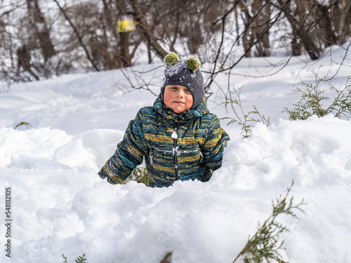 Happy baby boy playing in the snow