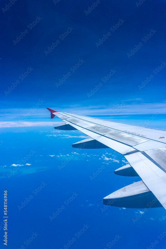 Obraz premium Airplane Wing in Flight from window, blue sky. 