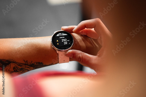 closeup left arm of young caucasian woman with smartwatch indicating calories burned after doing sports