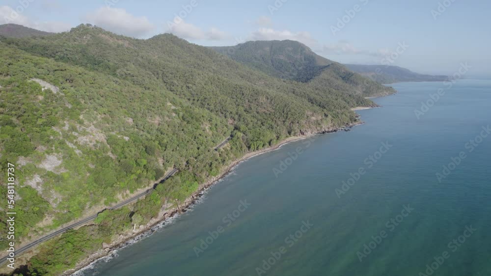 Captain Cook Highway Through Mountain Greeneries On The Coastline Between Cairns And Port Douglas In Wangetti, QLD, Australia. aerial Captain Cook Highway Through Mountain Greeneries On The Coastline Between Cairns And Port Douglas In Wangetti, QLD, Australia. aerial