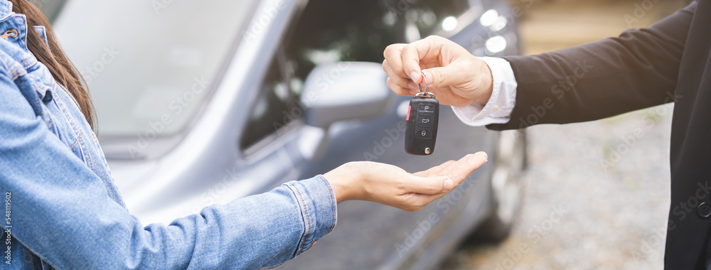 Business car rental, sell or buy service, dealership hand of agent dealer, sale man giving auto key of vehicle to customer renter, buyer young woman receiving, client or tenant, transfer automobile. - obrazy, fototapety, plakaty 