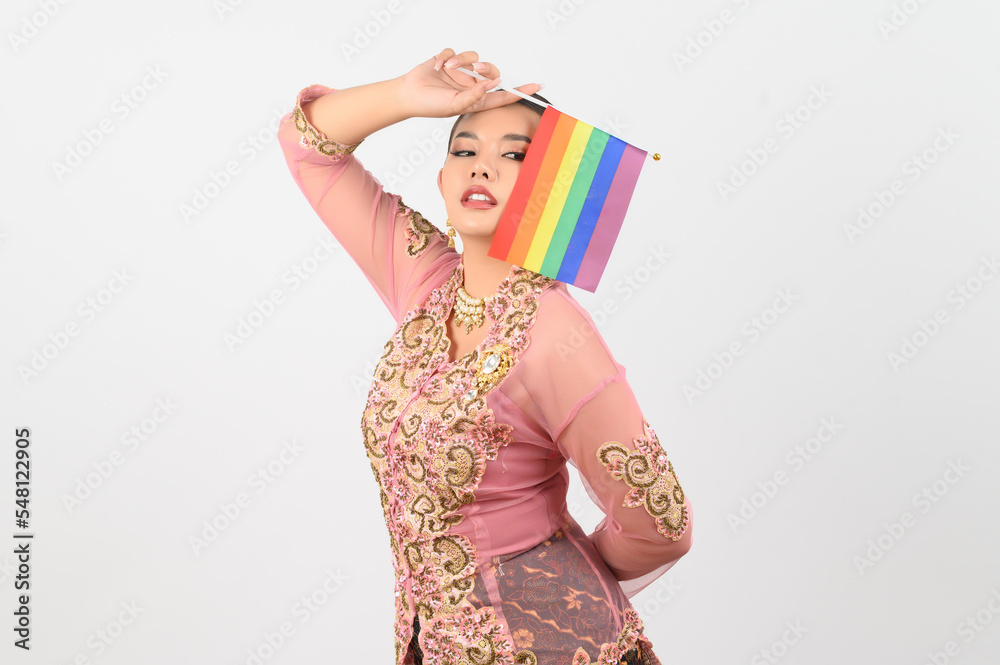 Young beautiful woman dress up in local culture in southern region with rainbow flag Young beautiful woman dress up in local culture in southern region with rainbow flag