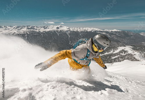 Close up photo of fast snowboarder in cloud of powder snow at ski slope
