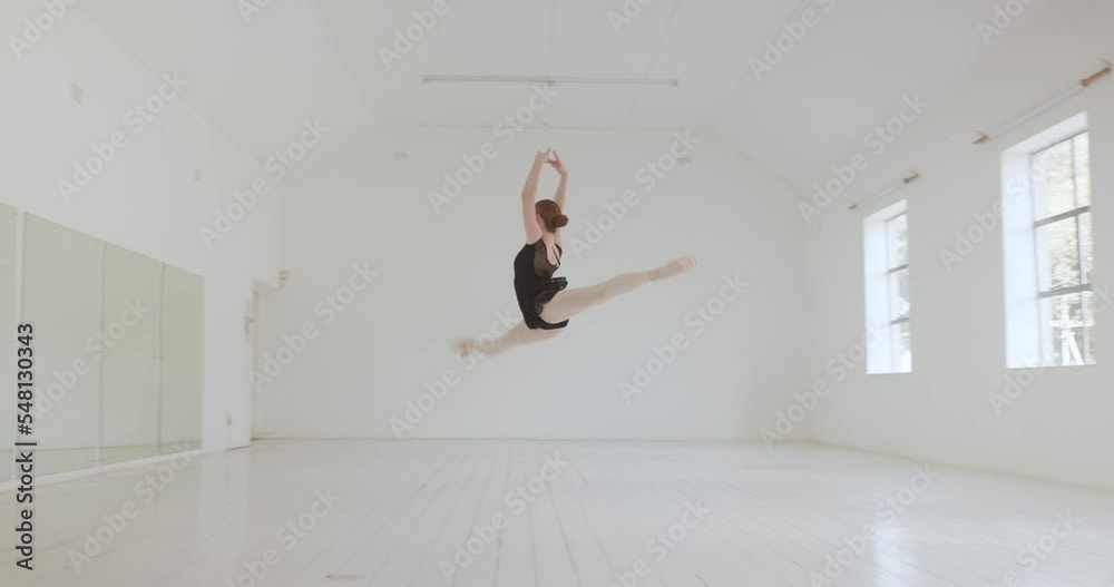 Ballerina, ballet dancer and split jumping performance, training rehearsal and choreography with split jumping technique in dance studio. Graceful, elegant and creative woman dancing skill practice