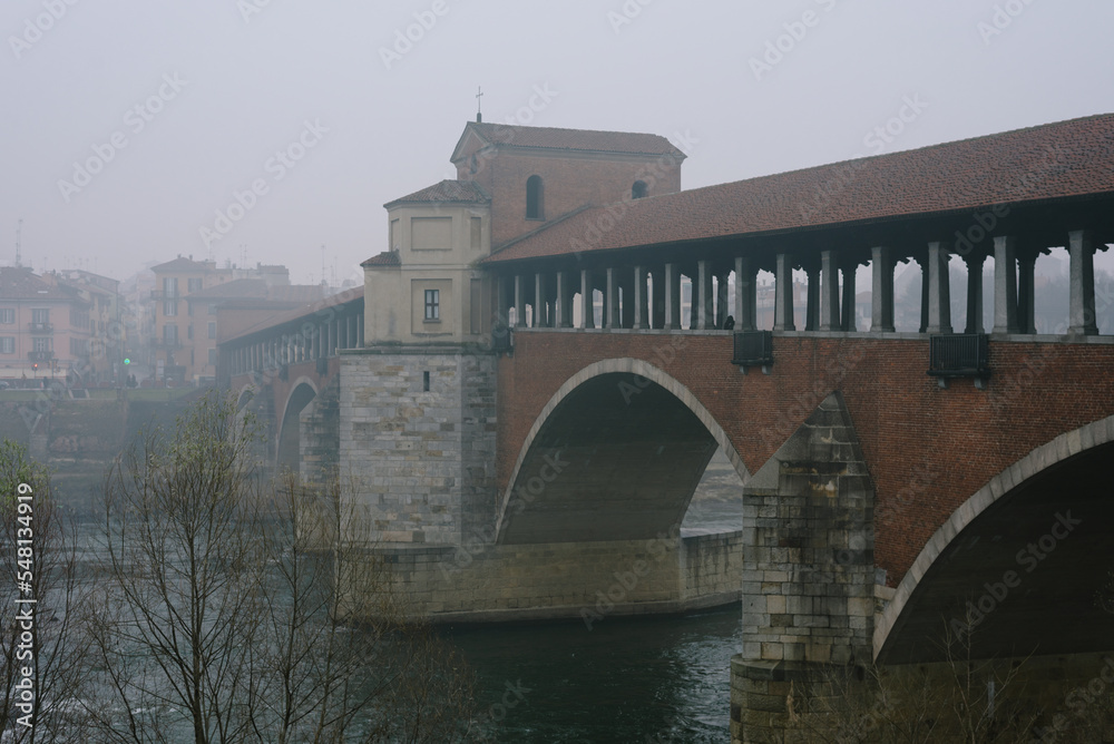 Ancient covered bridge surrounded by fog in winter. Pavia. Italy Ancient covered bridge surrounded by fog in winter. Pavia. Italy