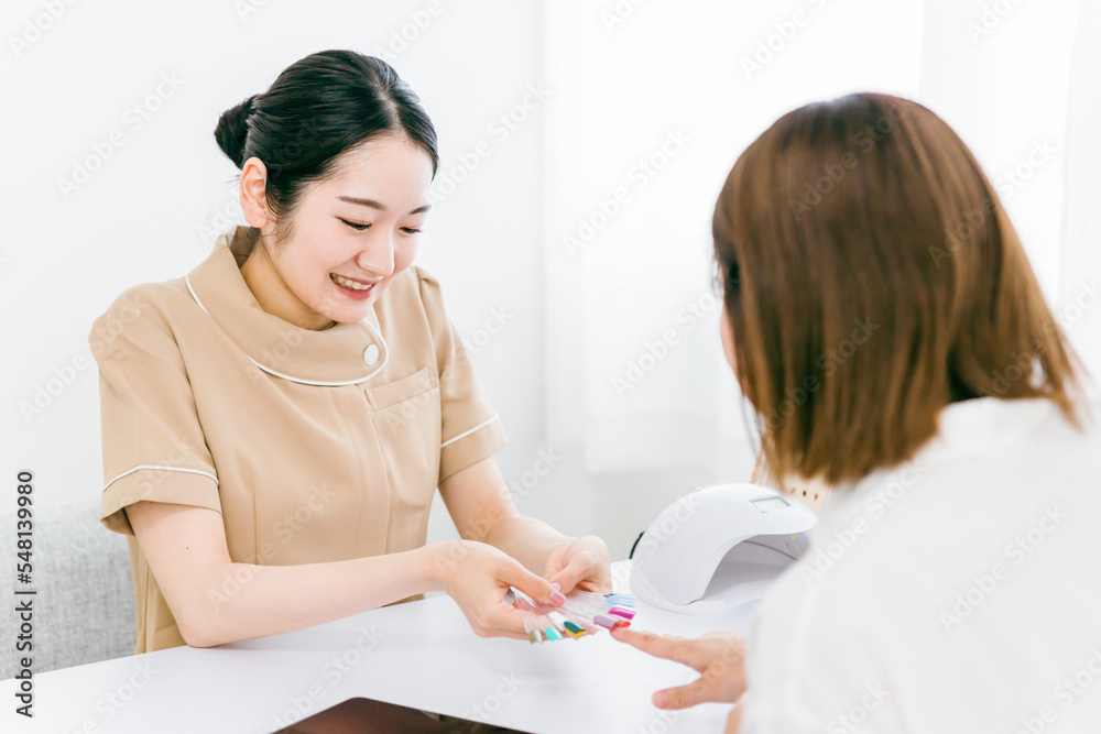ネイルサロンでネイルチップを使ってカラーとデザインのカウンセリングをするネイリストとアジア人女性
ネイルサロンでネイルチップを使ってカラーとデザインのカウンセリングをするネイリストとアジア人女性