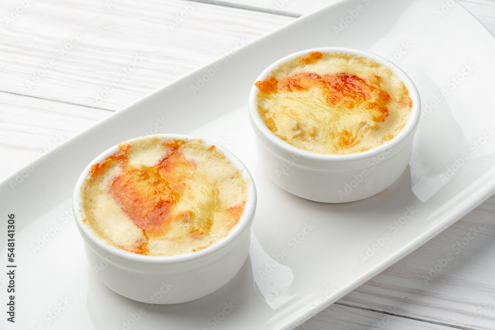 Baked julienne with mushrooms and cheese on top on white plate Baked julienne with mushrooms and cheese on top on white plate