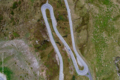 Aerial view of serpentine road with car of Swiss mountain pass Oberalppass on a cloudy late summer day. Photo taken September 5th, 2022, Oberalp Pass, Switzerland.