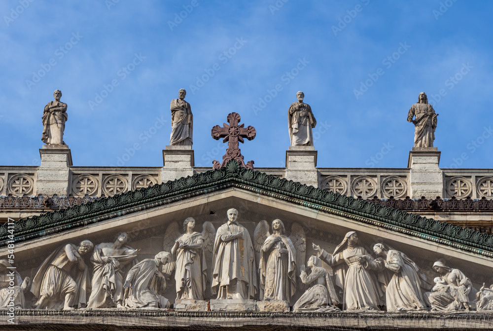 Fototapeta premium Tympanum and the statues of the church of Saint Vincent de Paul on a sunny day (blue sky), Paris, France.