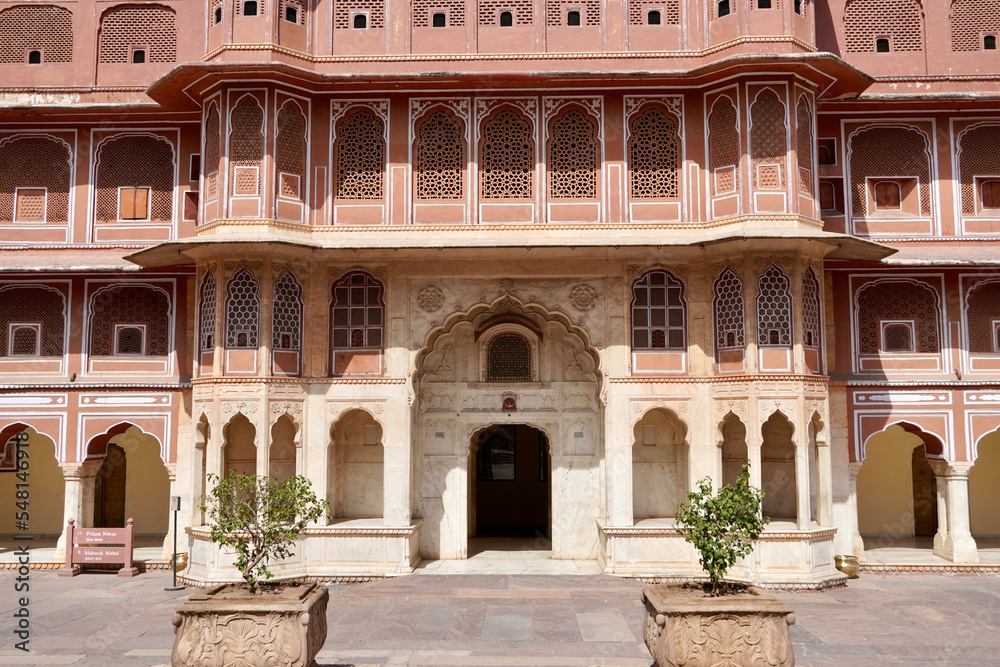 Chandra Mahal at the complex of city palace in Jaipur, India. Front facade elevation tower of ancient palace against blue sky background.