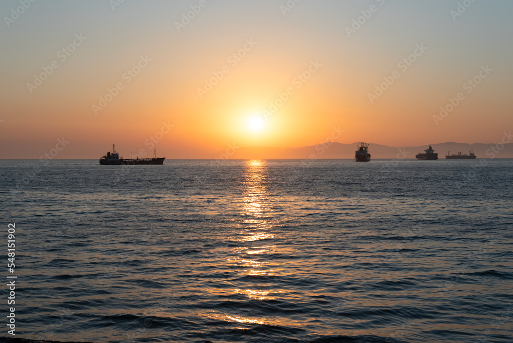 Beautiful orange sunset over the sea with a silhouettes of ships and soft selective focus. Beauty of nature concept Beautiful orange sunset over the sea with a silhouettes of ships and soft selective focus. Beauty of nature concept