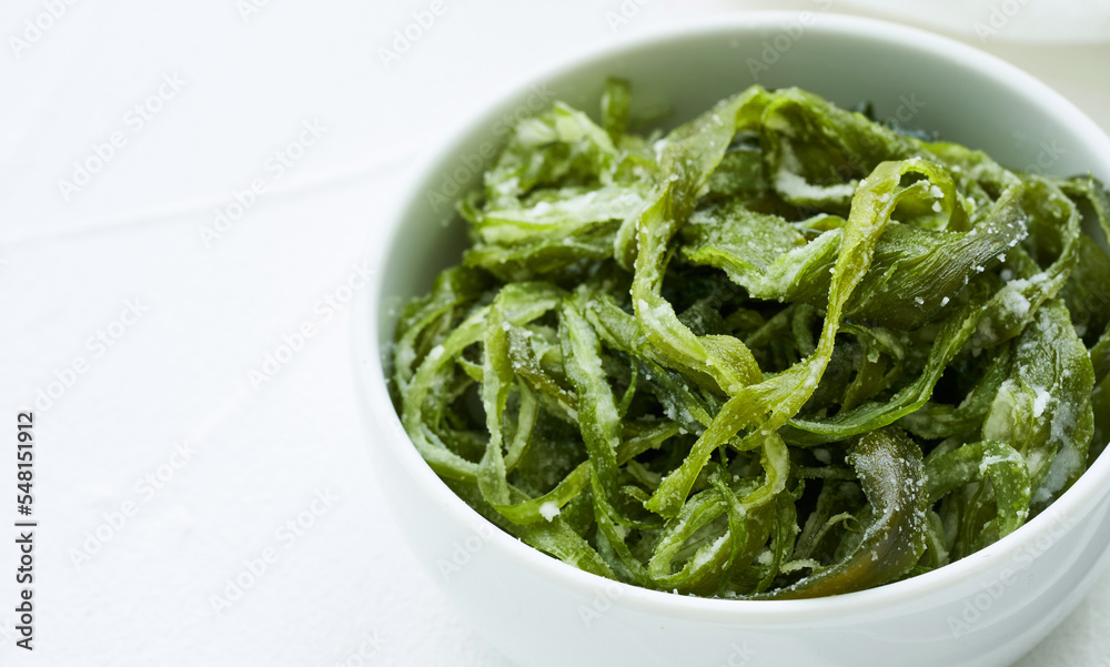 heap of fresh Korean salted seaweed salad stem side dish or Miyeok Julgi Bokkeum in white bowl on white background. Laminaria or Kelp Seaweed stem heap of fresh Korean salted seaweed salad stem side dish or Miyeok Julgi Bokkeum in white bowl on white background. Laminaria or Kelp Seaweed stem