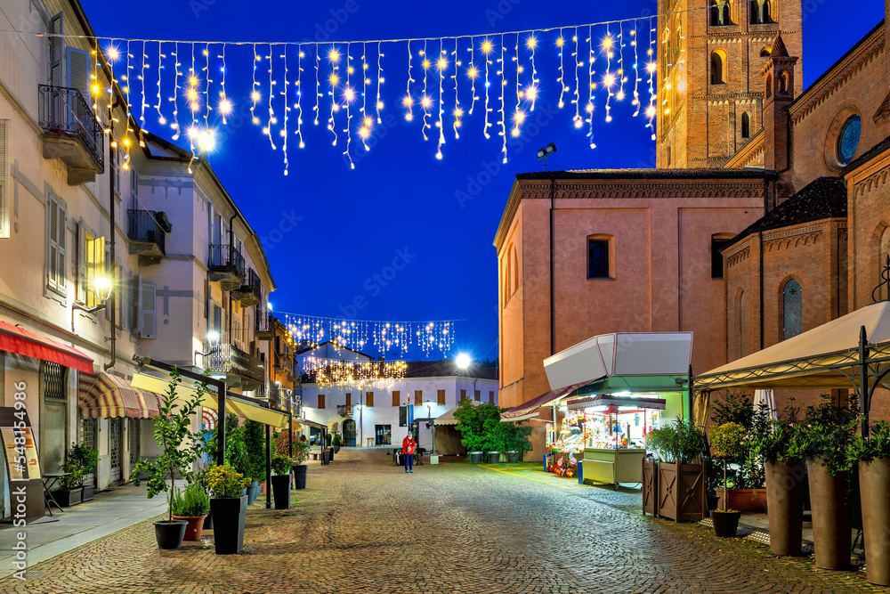 Fototapeta premium Cobblestone street in old town of Alba illuminated with Christmas lights.